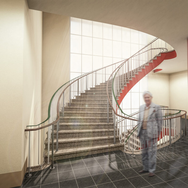 Innenraumperspektive der Haupttreppe im Erich-Rammler-Baus. Die steinerne Treppe ist geschwungenen und liegt vor einem Raumhohen Fenster. Der Raum wirkt offen und hell.