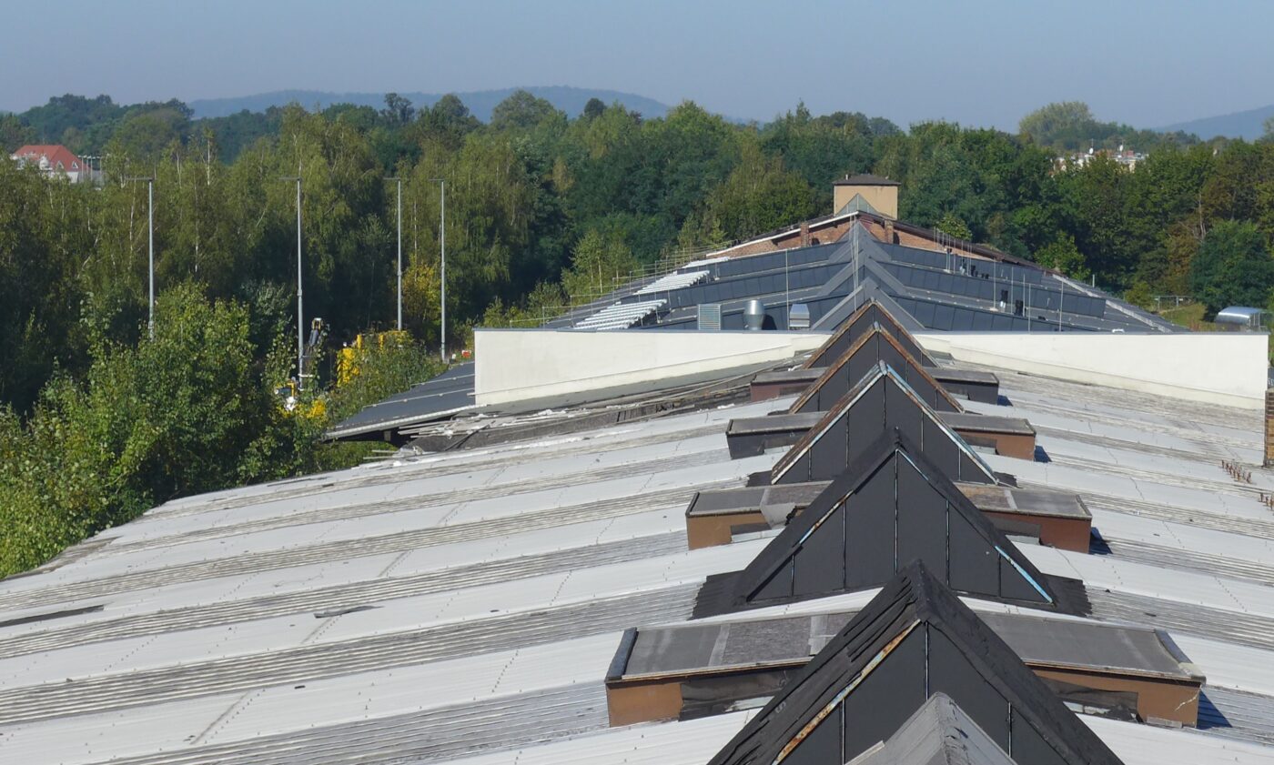 Flaches Satteldach des Bahnhofes mit spitzen Aufbauten